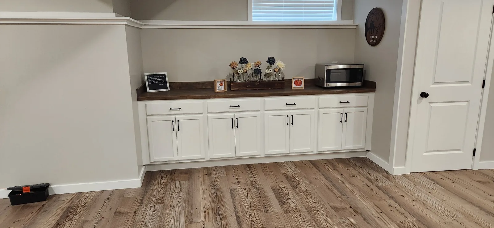 Built-in basement cabinetry with stained countertop and white shaker doors