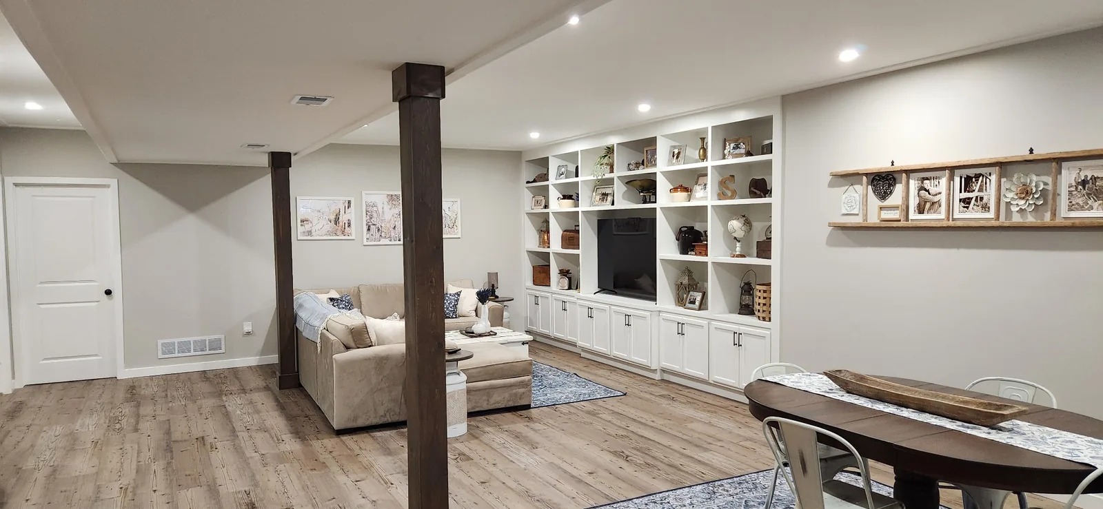 Finished basement family room with custom entertainment built-ins and cabinetry by New Beginnings Construction and Design